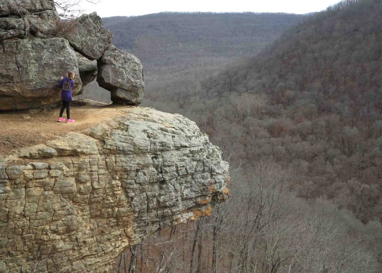 Young hiker taking in the views and staying away from the edge. 